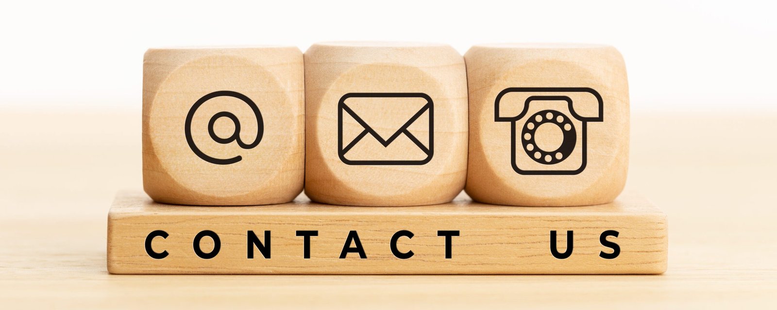 Contact us concept. Wooden blocks with email, mail and telephone icons.Website page contact us or e-mail marketing